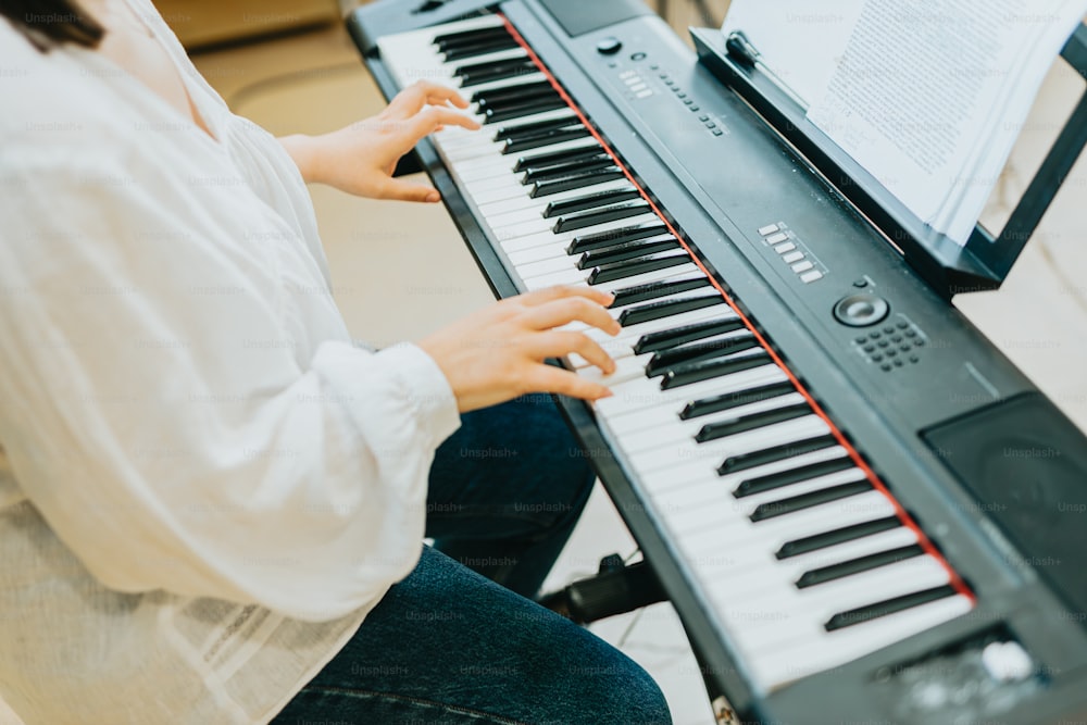 a woman sitting at a piano playing a musical instrument