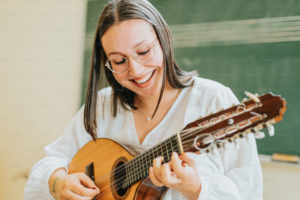 a woman playing a guitar in front of a chalkboard