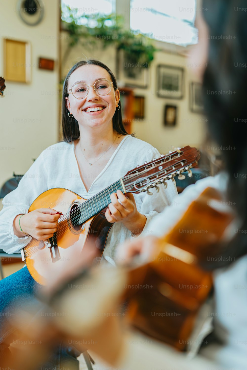 una donna seduta su una sedia che suona una chitarra