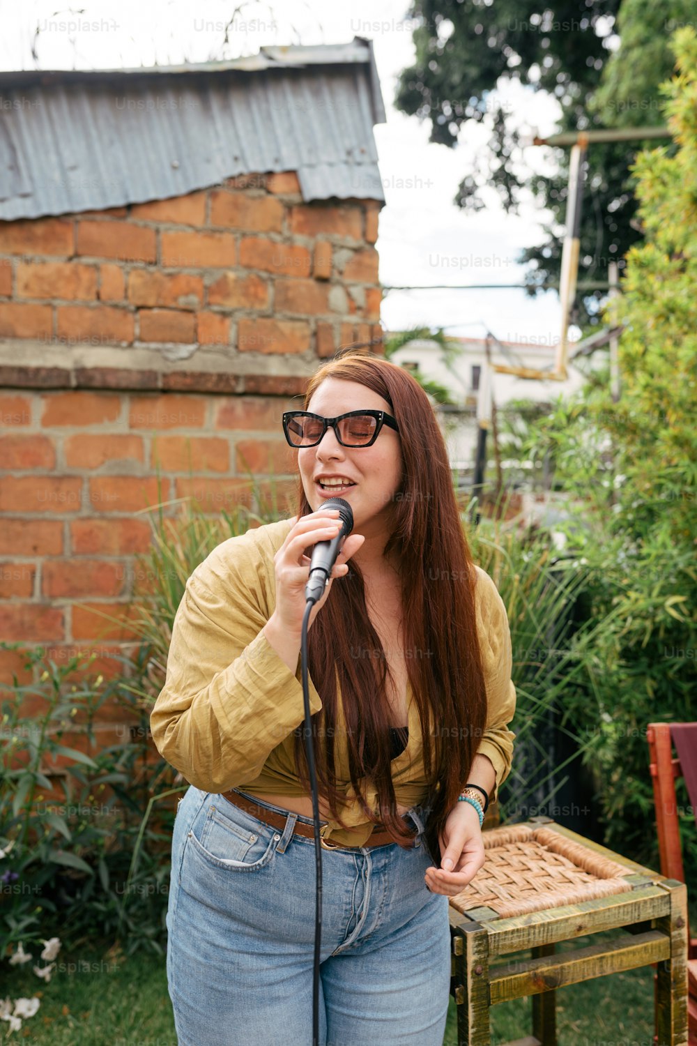 a woman with glasses is singing into a microphone