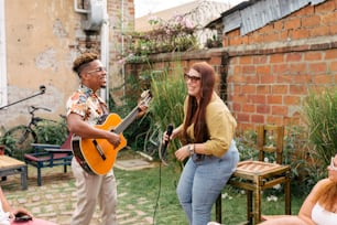 a man playing a guitar and singing into a microphone