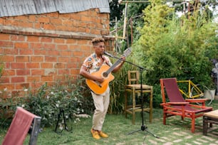 a man playing a guitar in a backyard