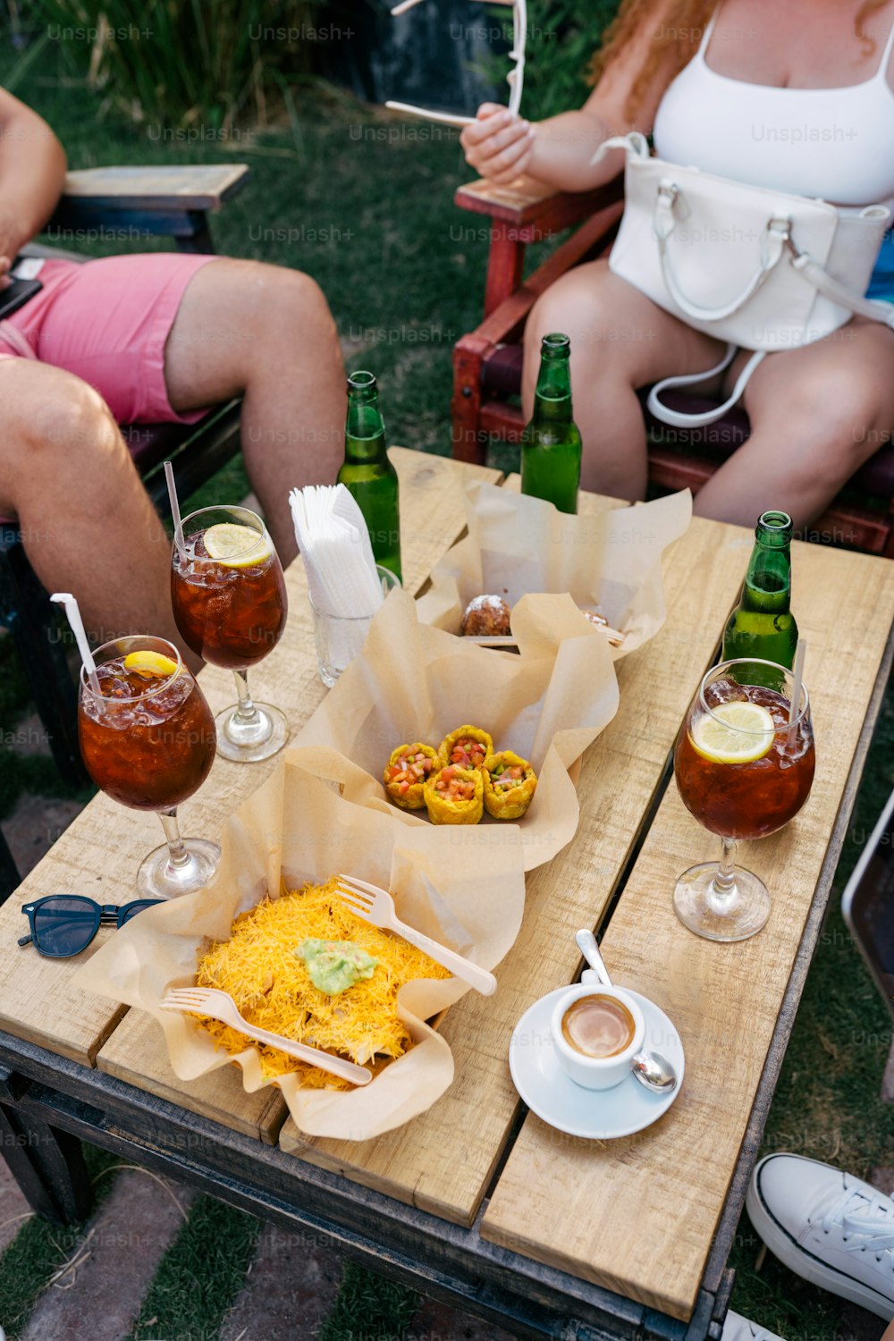 a group of people sitting around a table with food and drinks