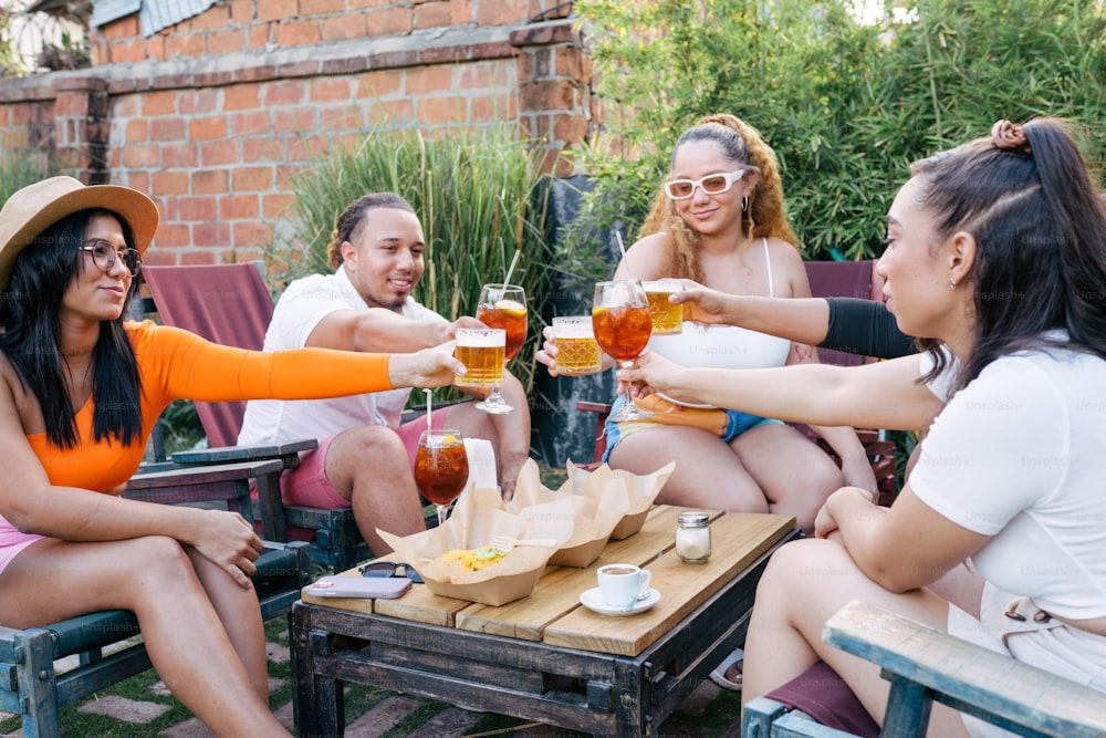 um grupo de pessoas sentadas ao redor de uma mesa com bebidas