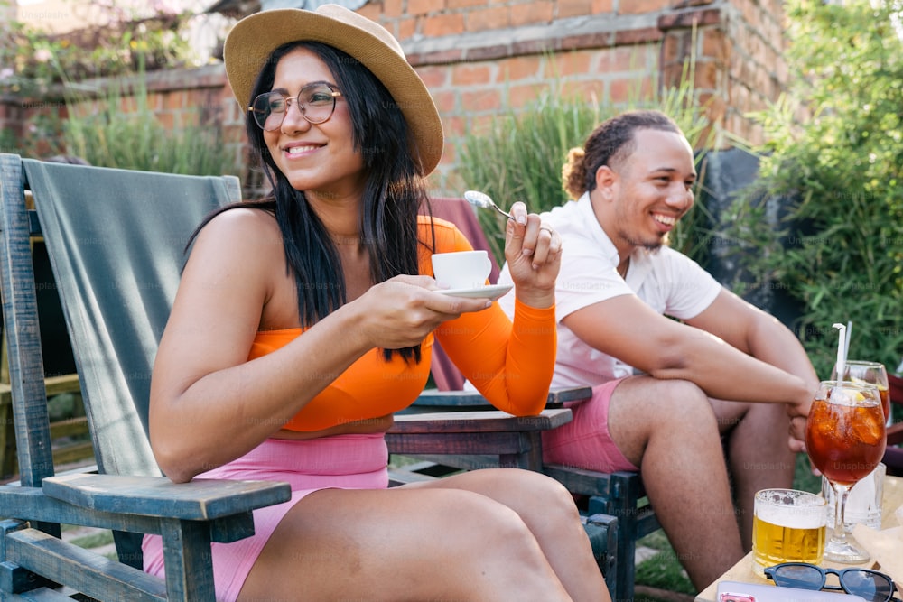 Ein Mann und eine Frau sitzen auf einer Bank mit Getränken