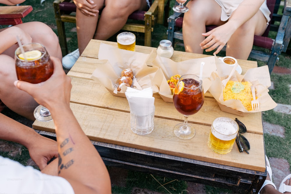 Un grupo de personas sentadas alrededor de una mesa con bebidas