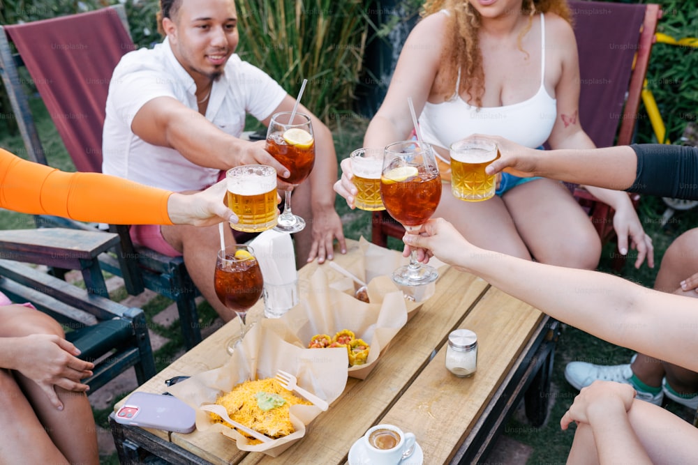 um grupo de pessoas sentadas ao redor de uma mesa com bebidas