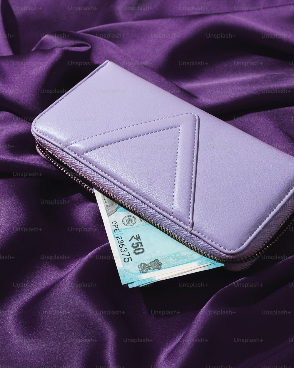 un portefeuille violet posé sur un tissu violet