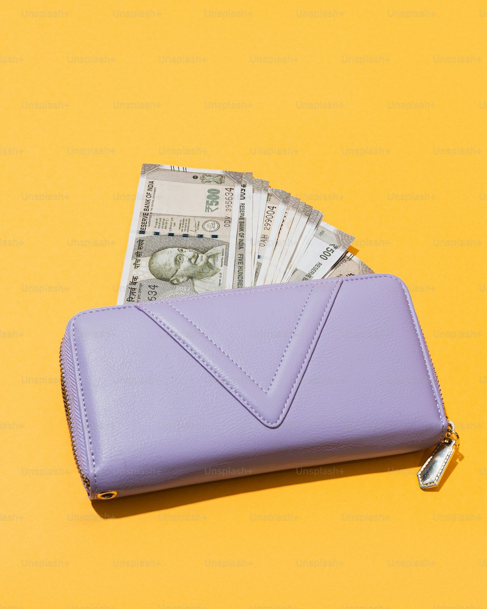Ein lila Portemonnaie, aus dem Geld herausragt