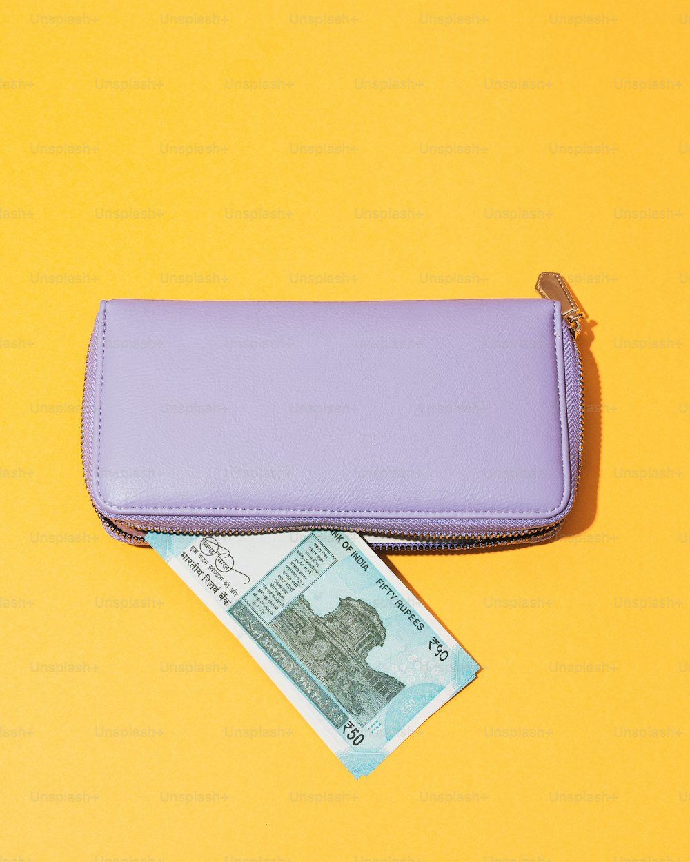 Un portafoglio viola seduto sopra un tavolo giallo