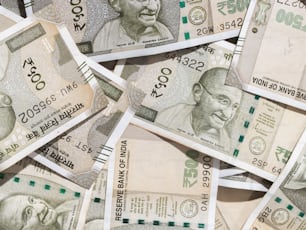 a pile of indian currency with a man on top of it