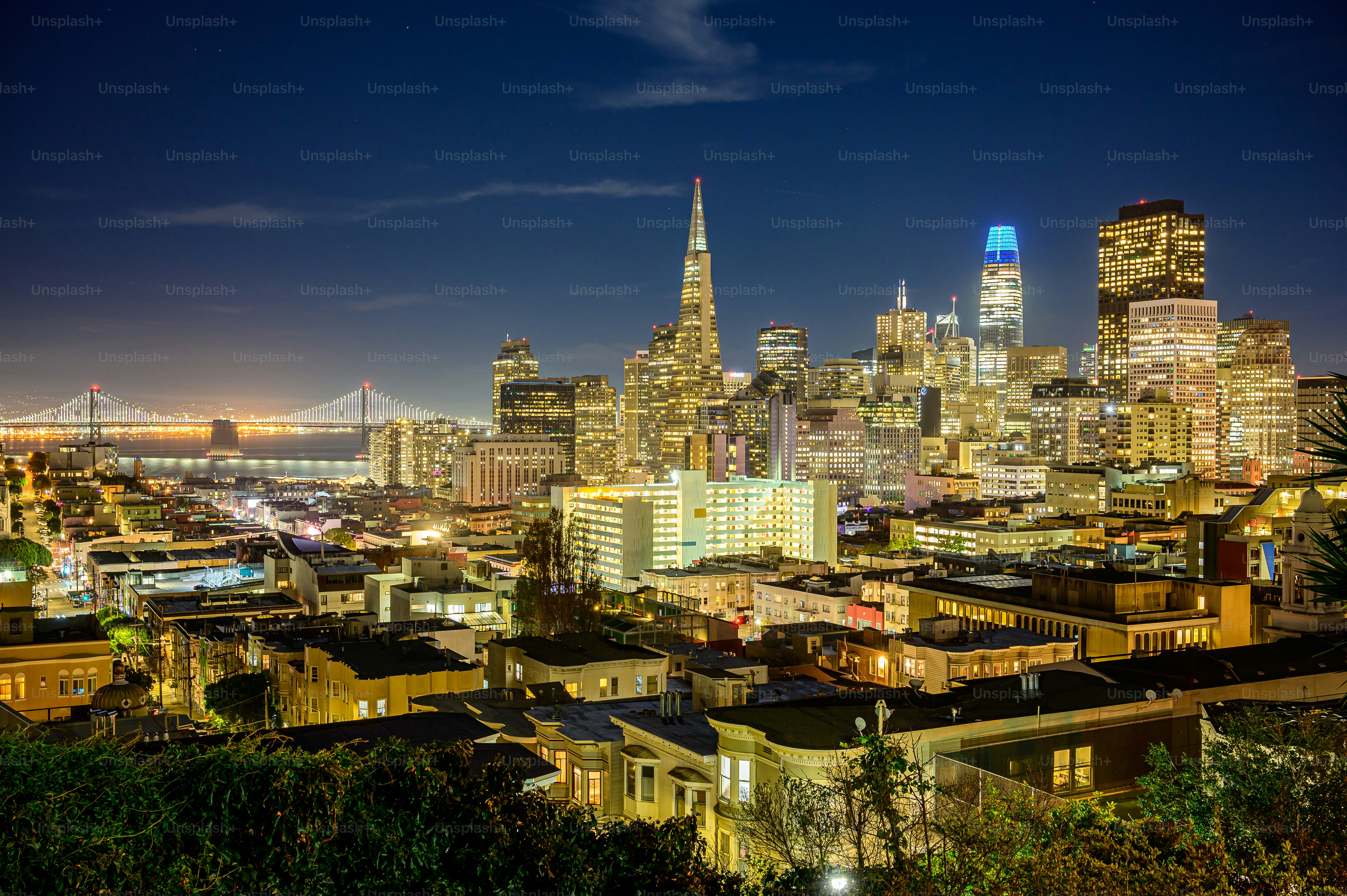 a view of a city at night with a bridge in the background