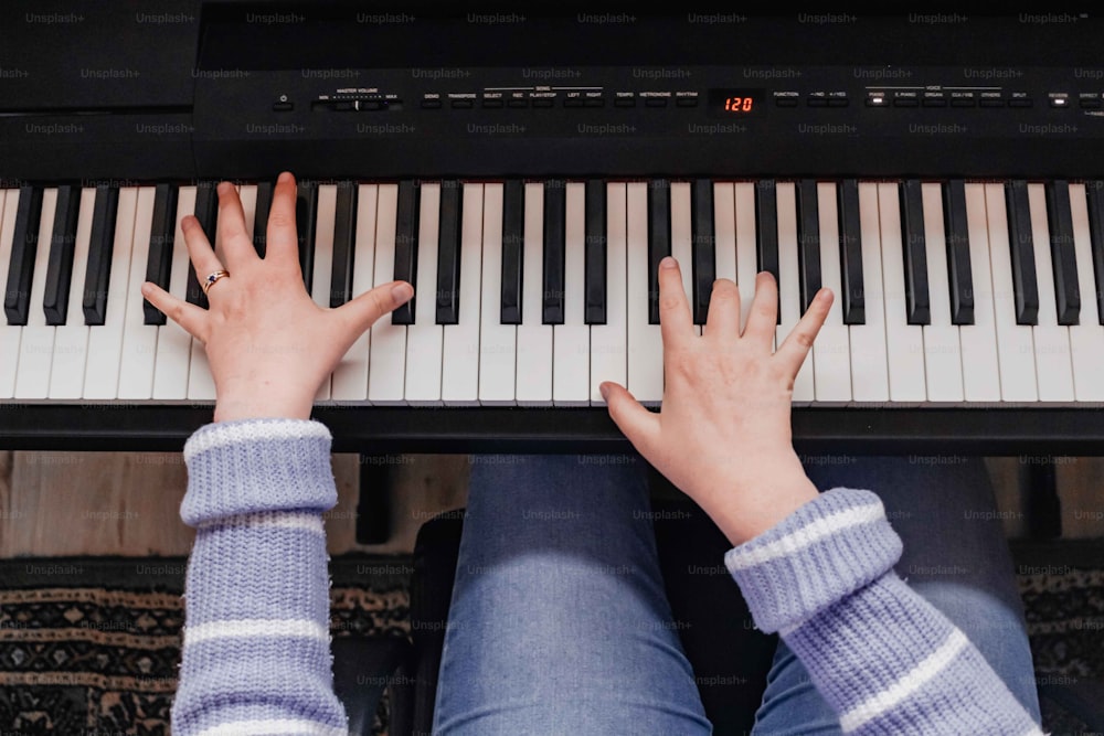 una persona tocando un piano con las manos