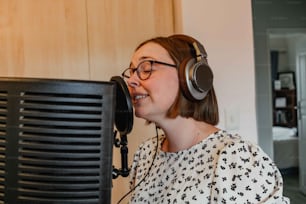 a woman wearing headphones is singing into a microphone