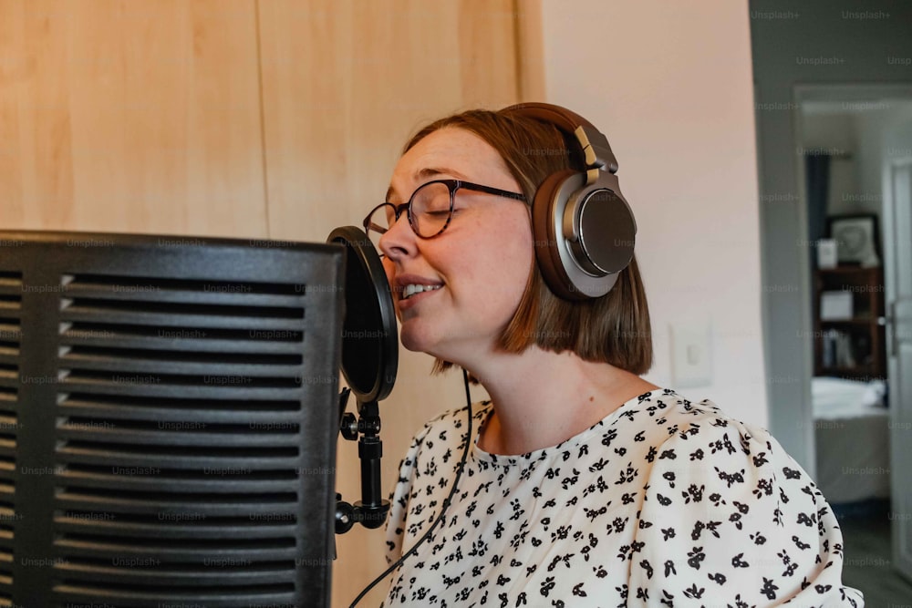 a woman wearing headphones is singing into a microphone