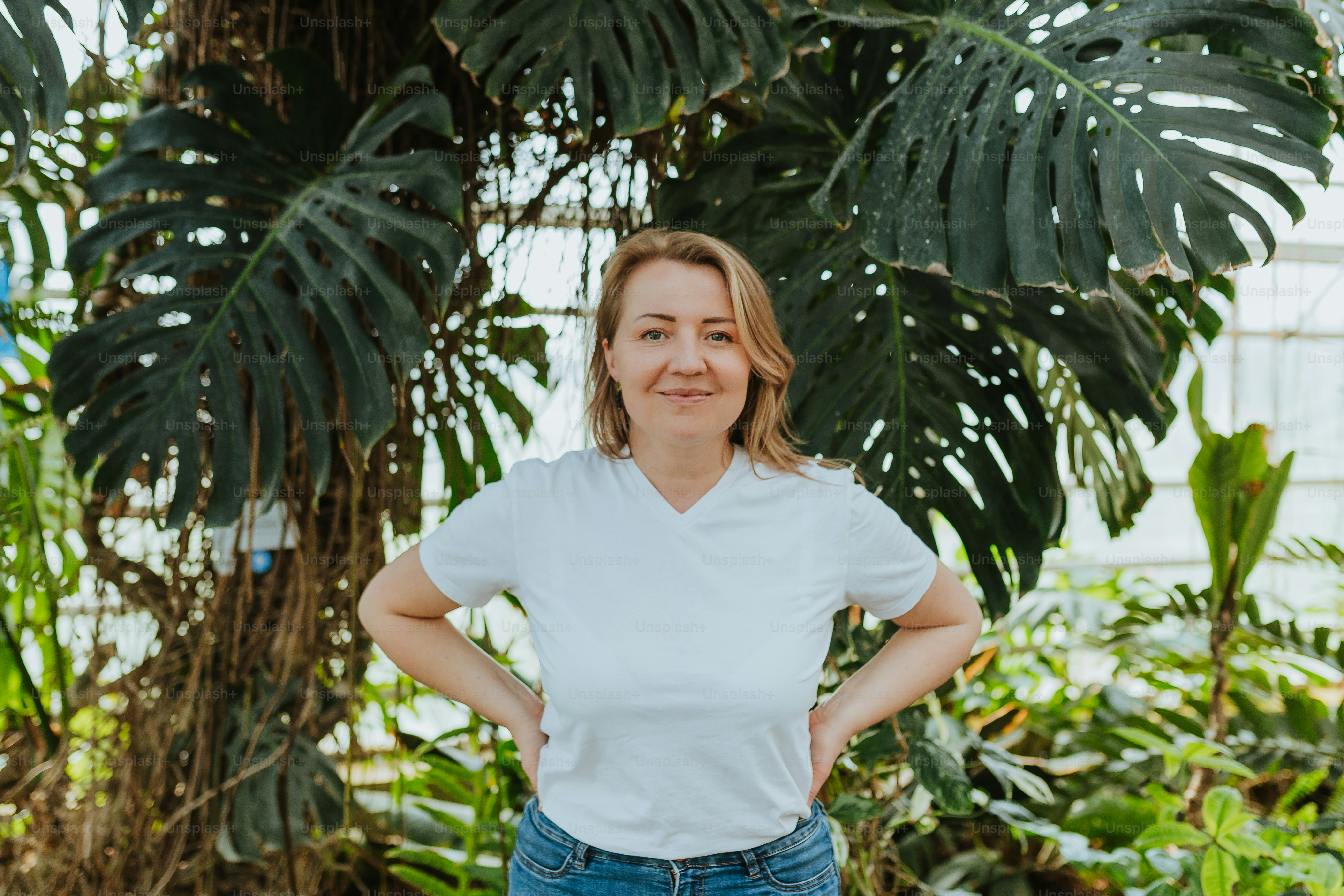 uma mulher em pé em uma estufa com as mãos nos quadris