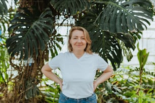 a woman standing in a greenhouse with her hands on her hips