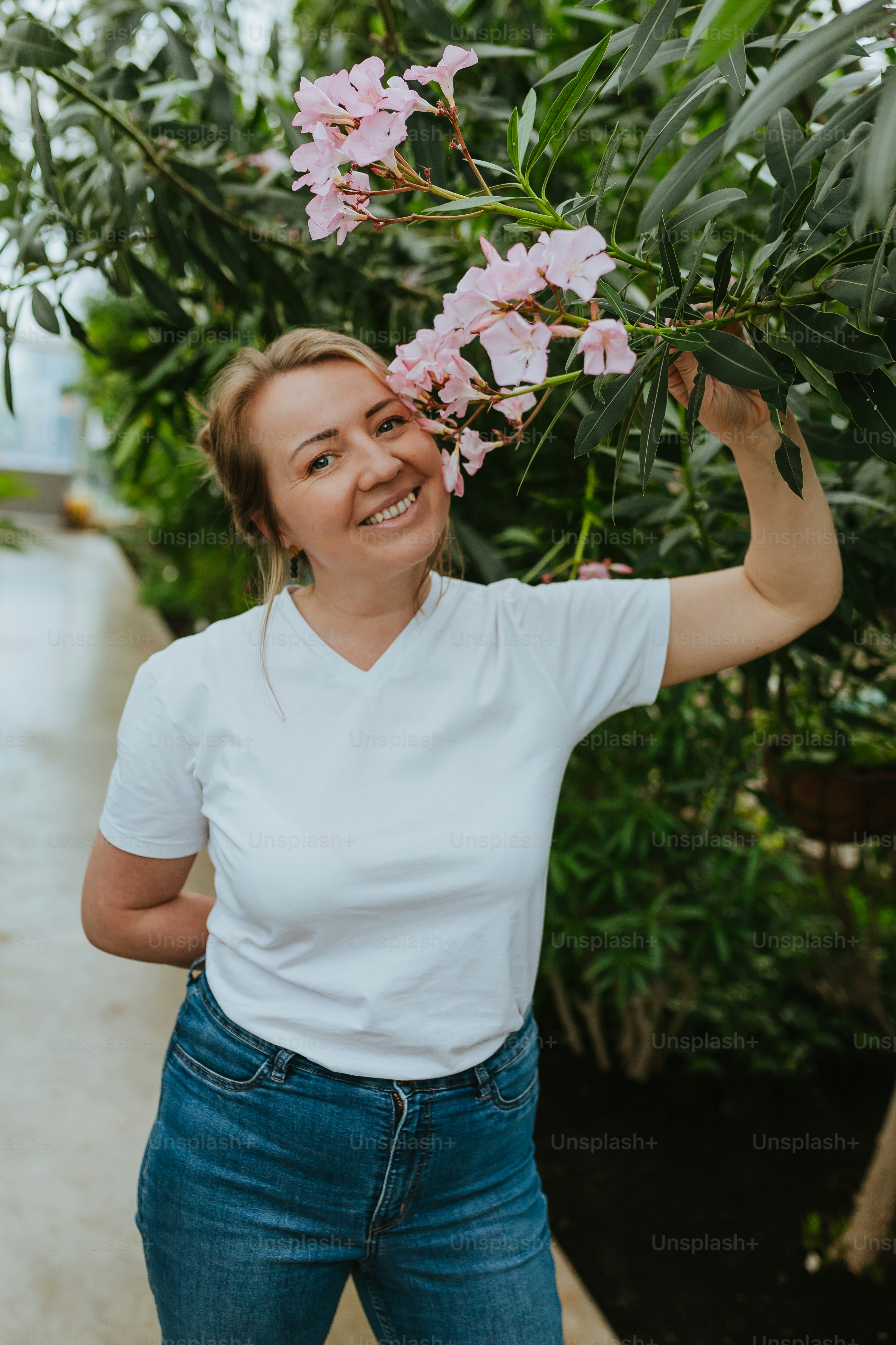 Una donna sorride mentre tiene in mano un fiore