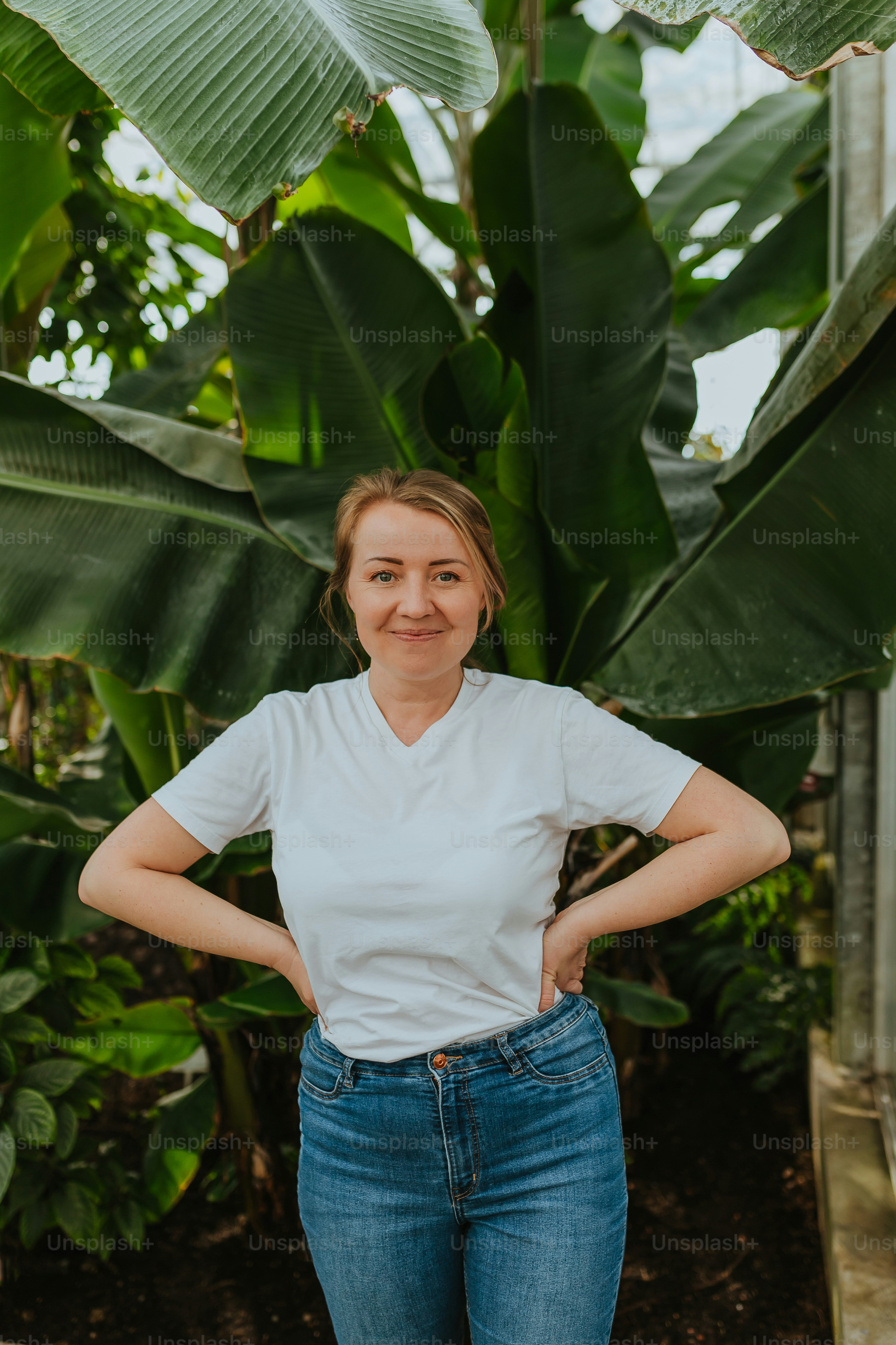 Una donna in piedi di fronte a una pianta verde