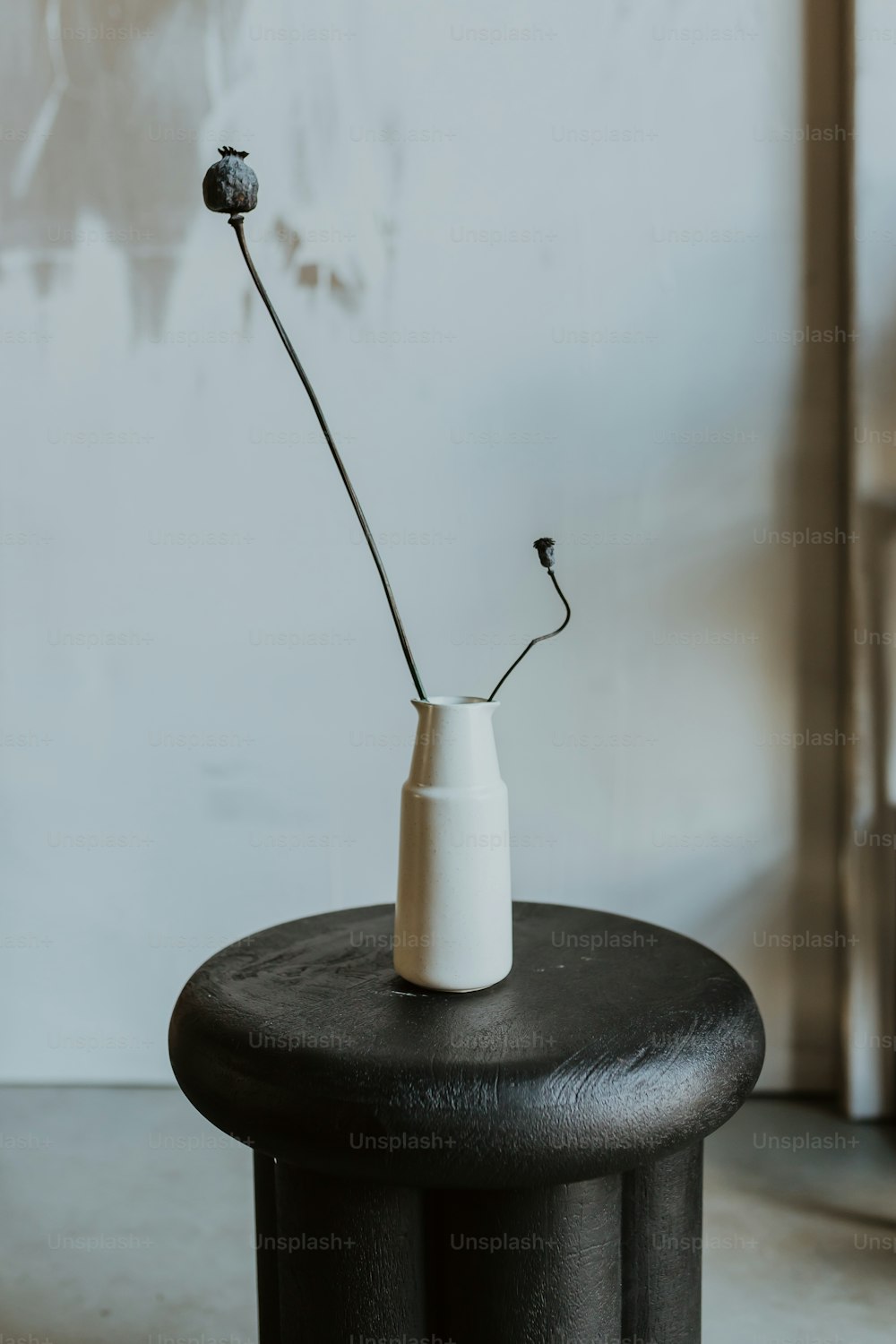 a white vase sitting on top of a black table