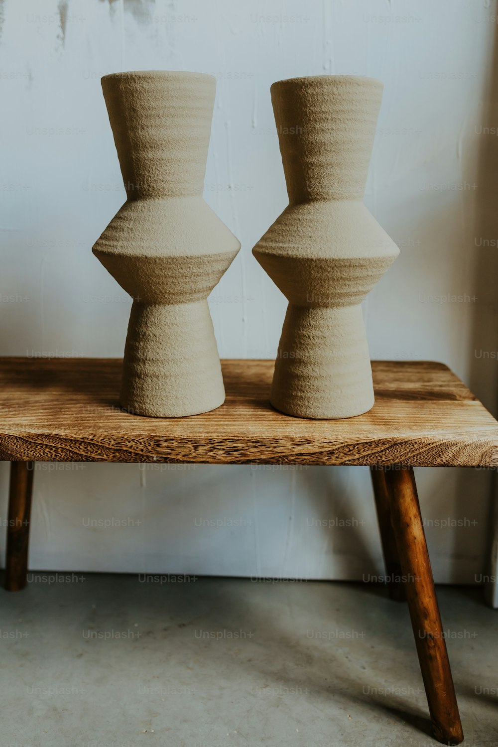 two vases sitting on top of a wooden table
