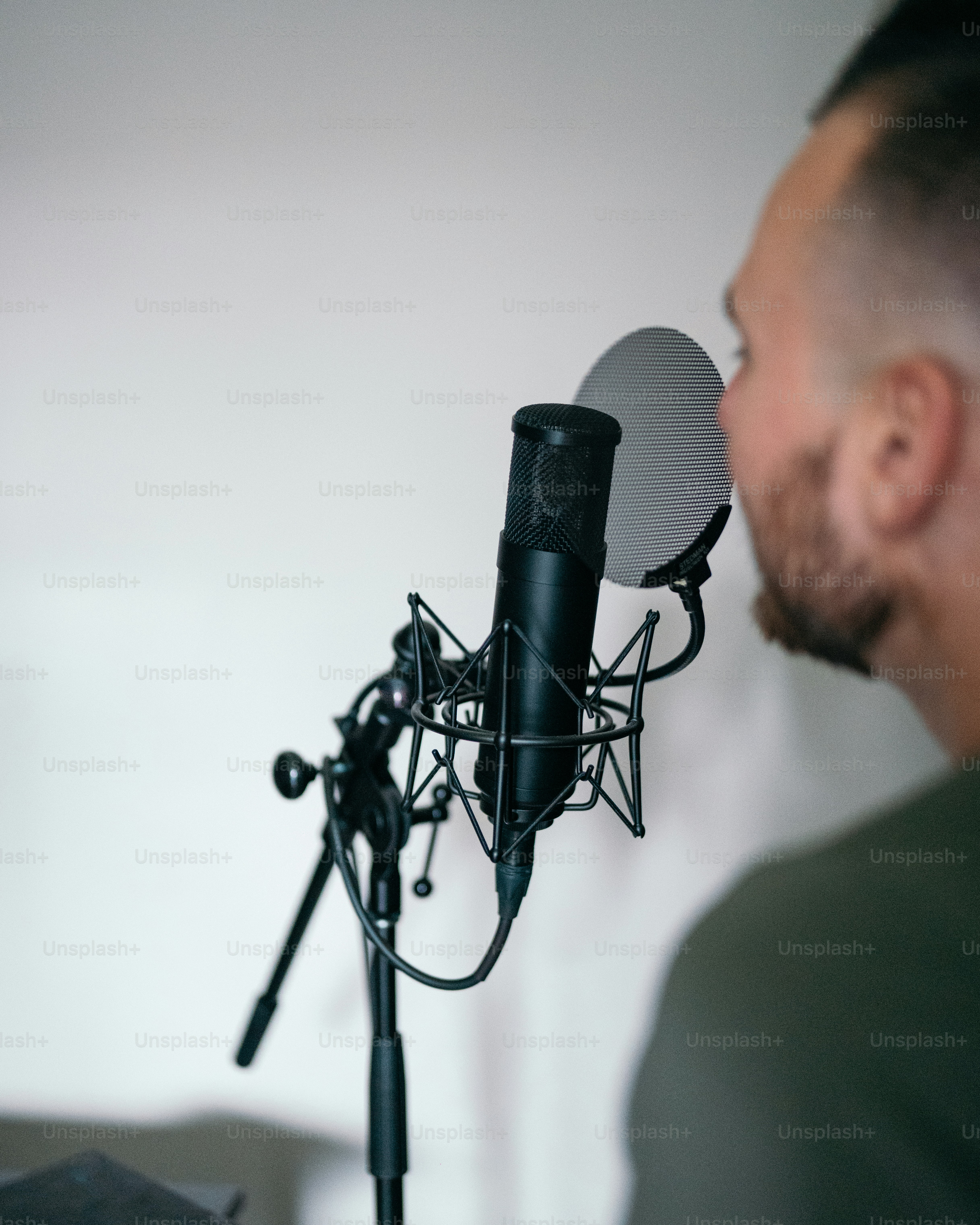 a man in a green shirt is looking at a microphone