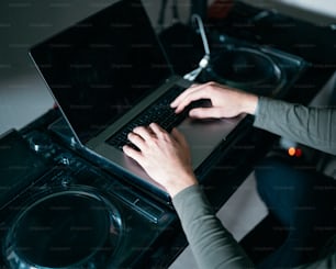 a person typing on a laptop in front of a washer