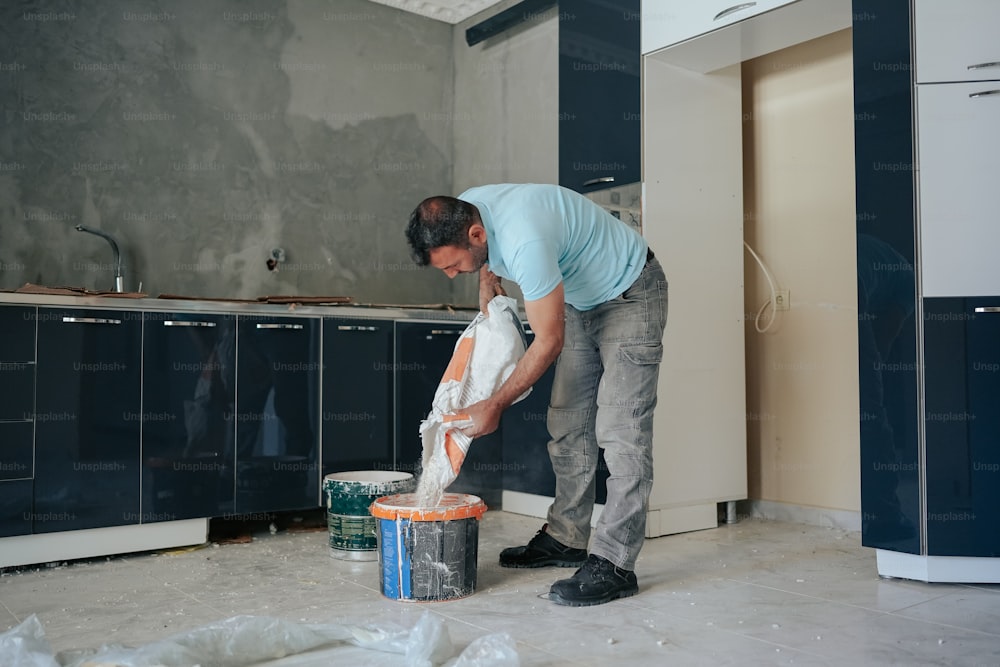 a man in a blue shirt is cleaning a kitchen