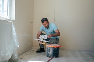Un hombre con una camisa azul está trabajando en un piso