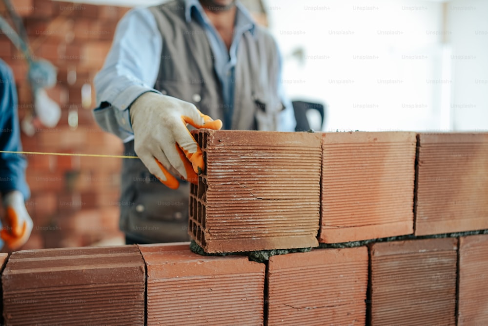 a man is placing bricks into a brick wall