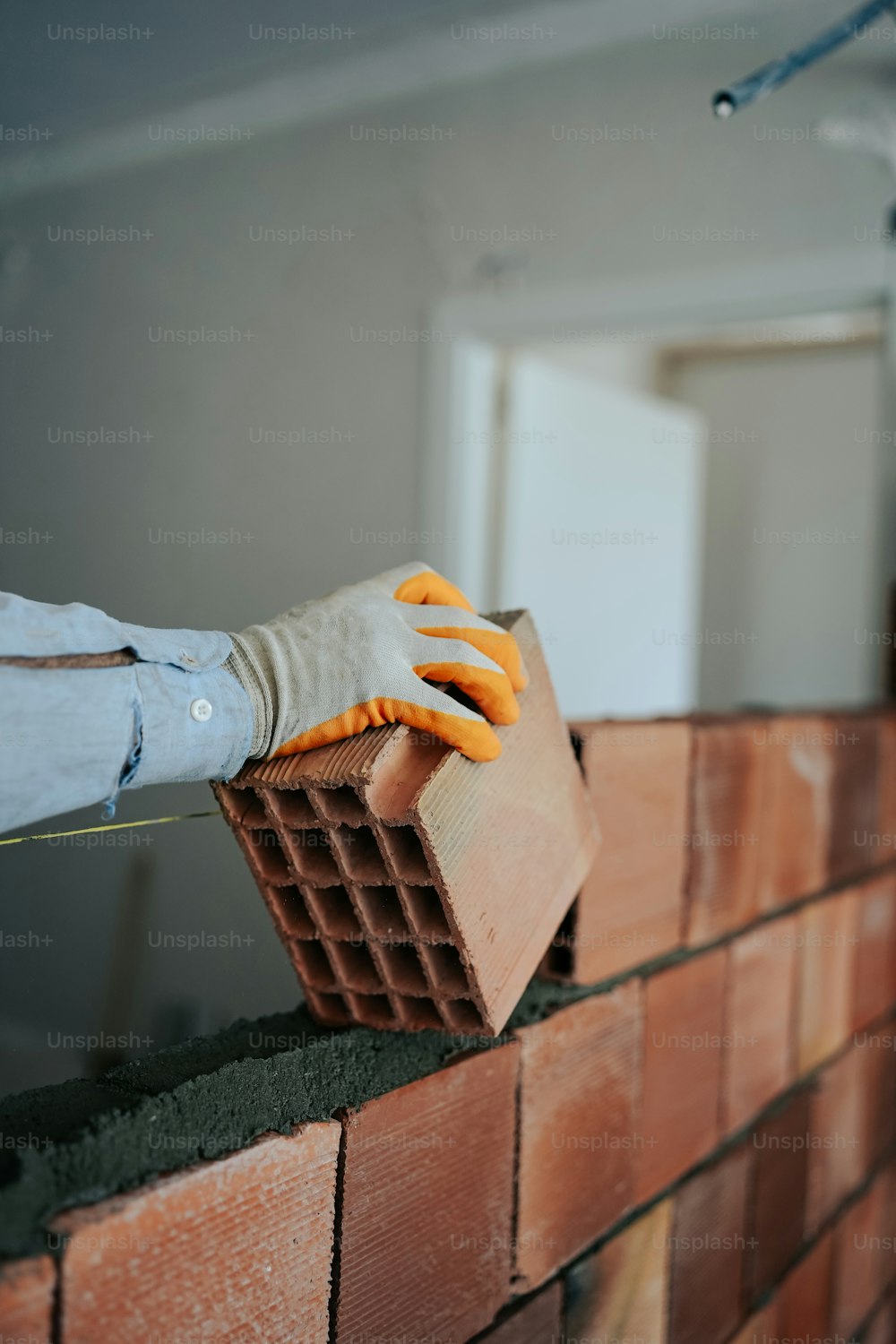 uma parede de tijolos sendo trabalhada por um trabalhador