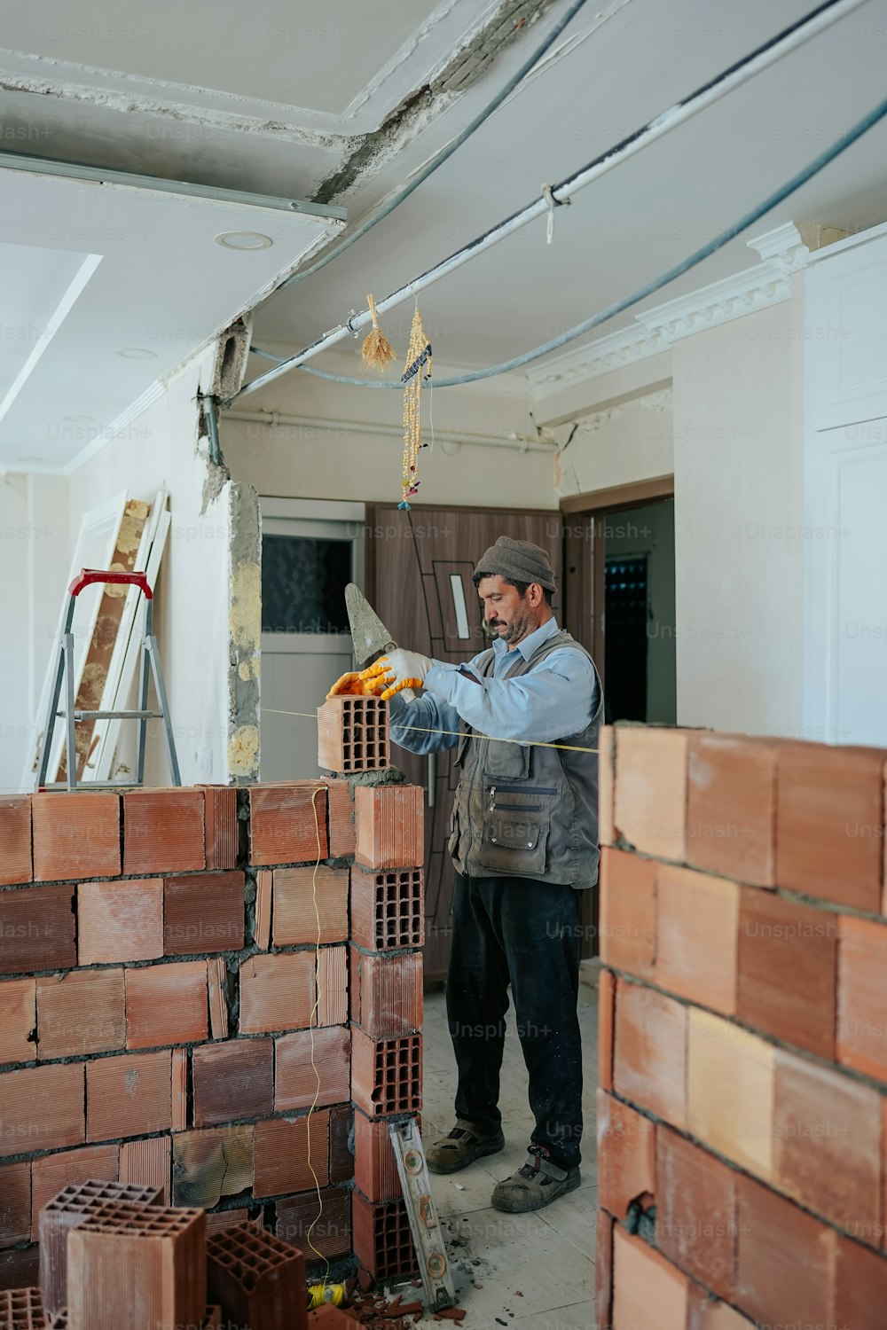 a man standing next to a pile of bricks