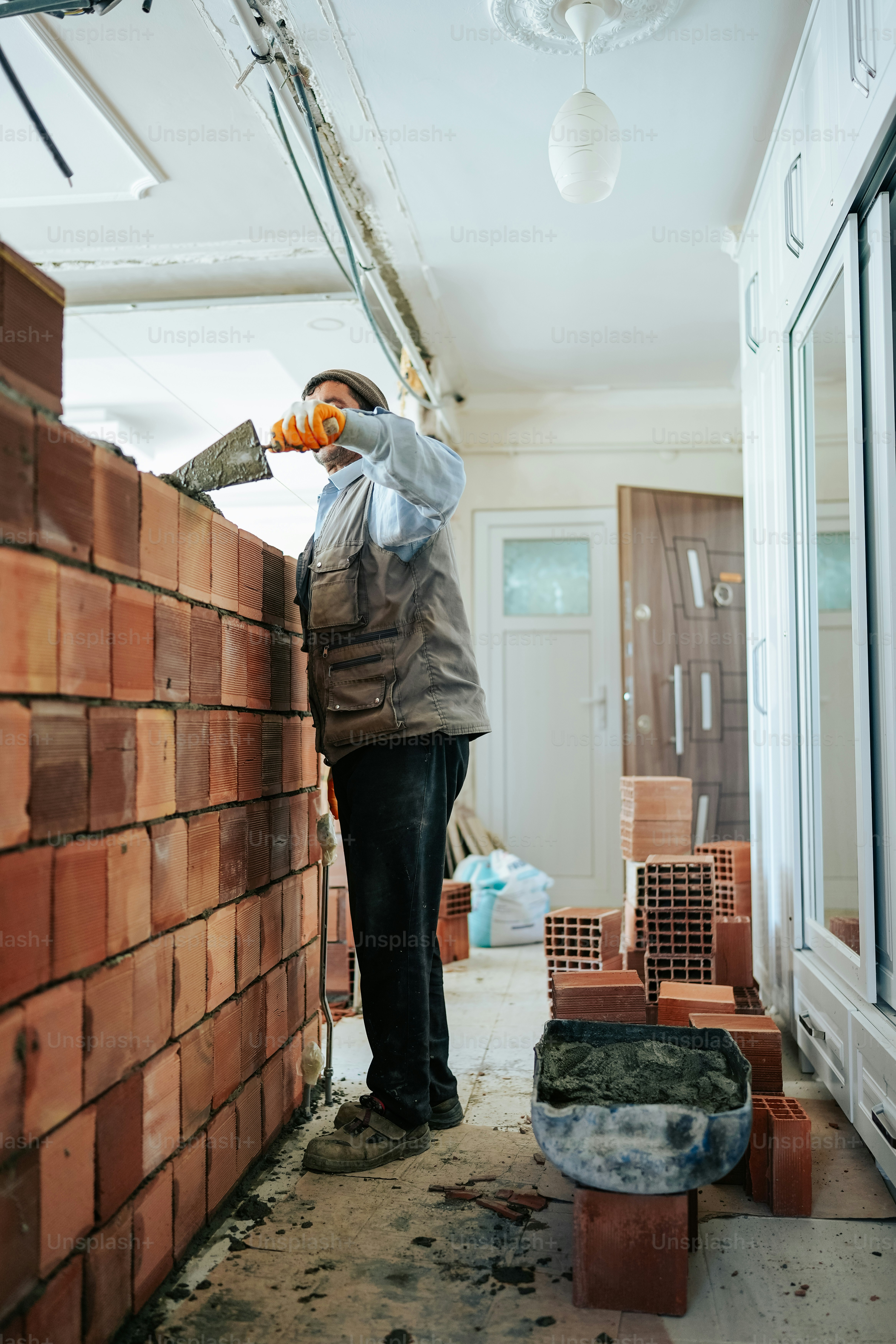 a person standing next to a brick wall