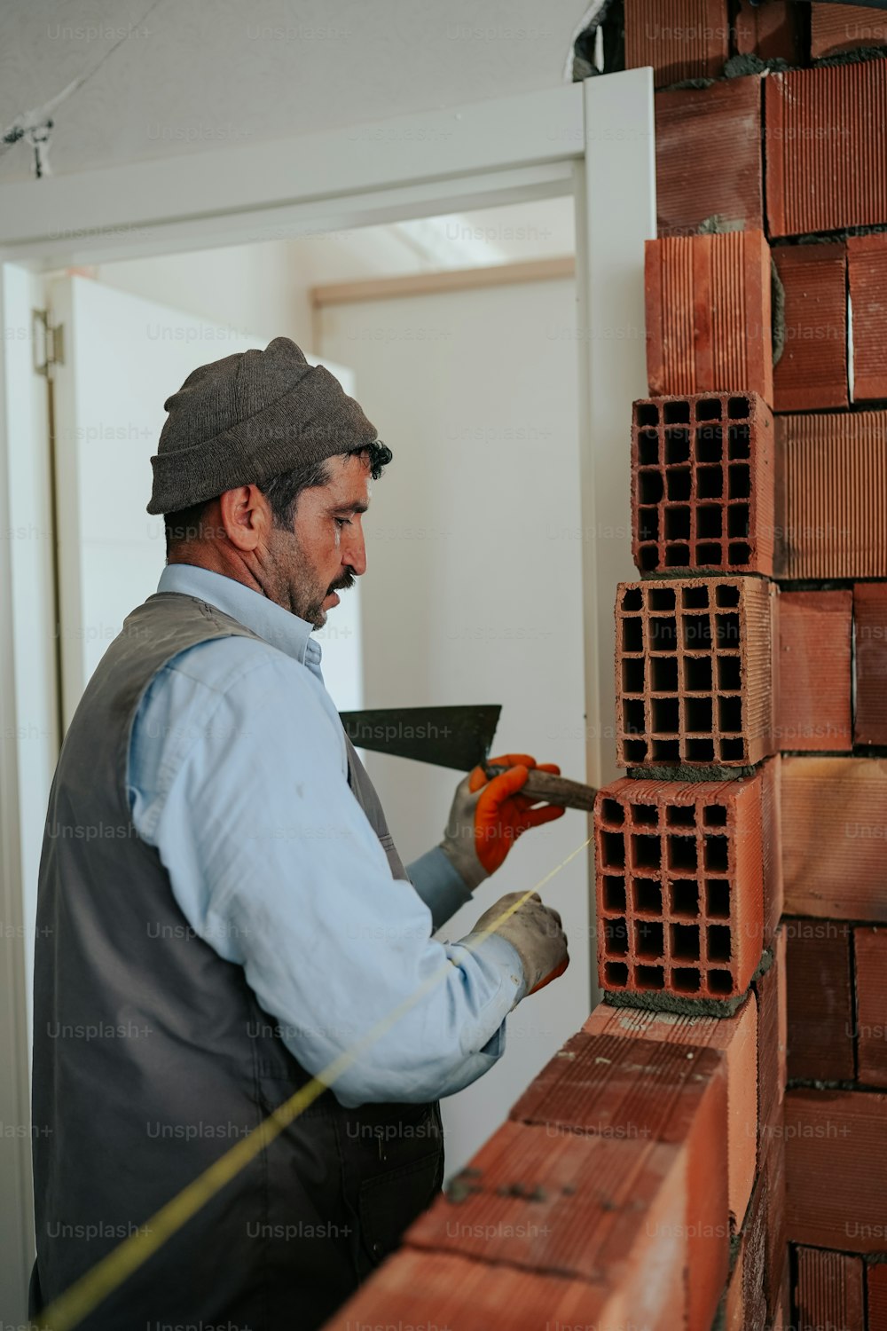 한 남자가 벽돌 벽에서 일하고 있다