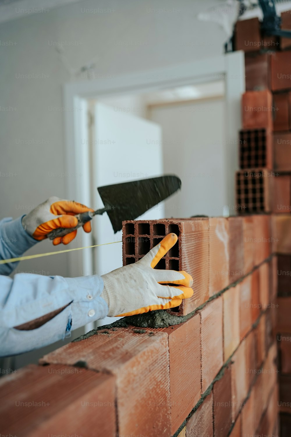 a brick wall being worked on by a bricklayer