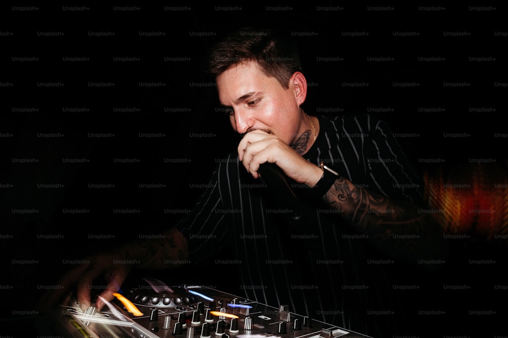 Un hombre que está sentado frente a un mezclador de DJ