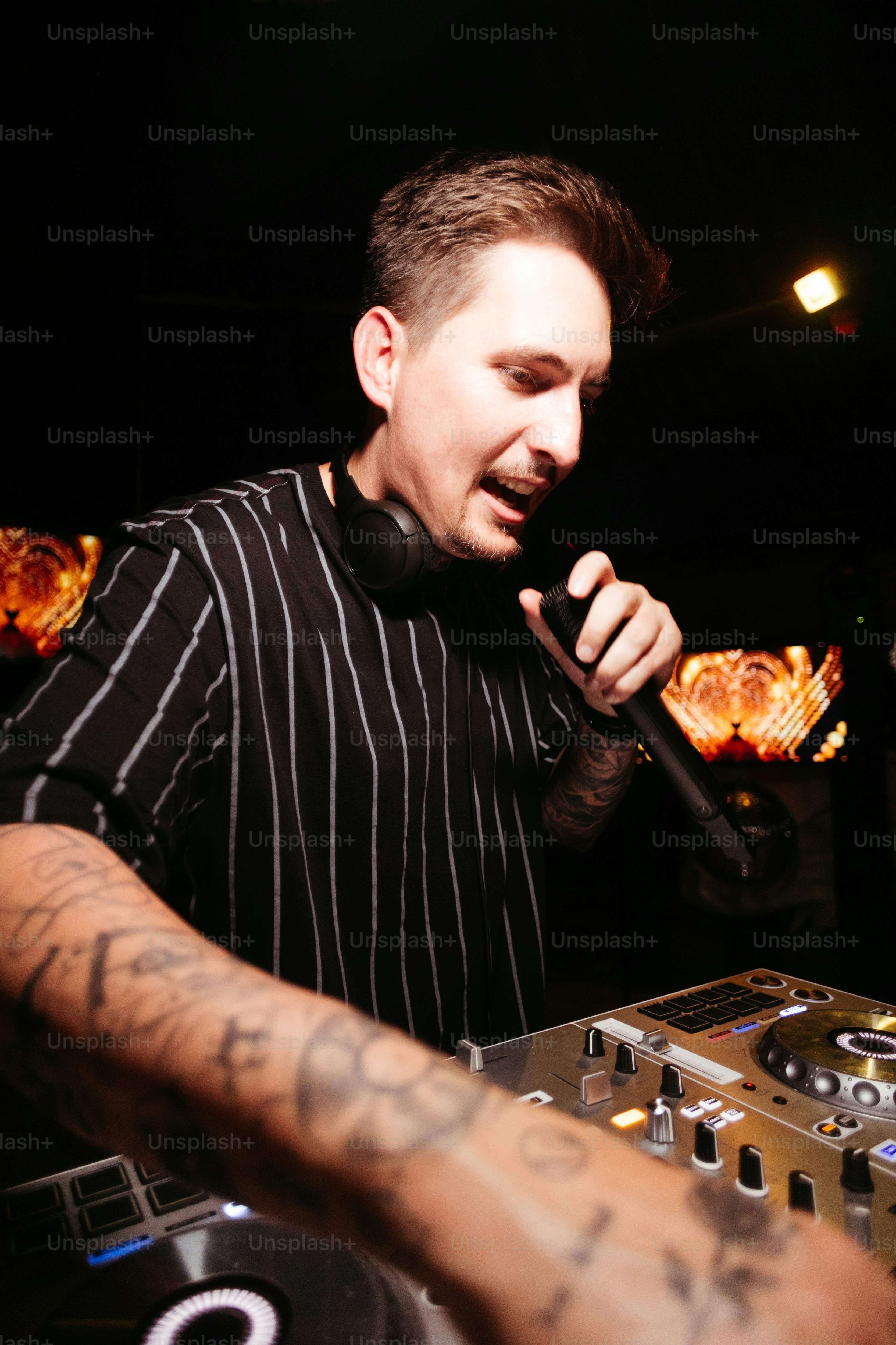 a man in a black and white striped shirt holding a microphone