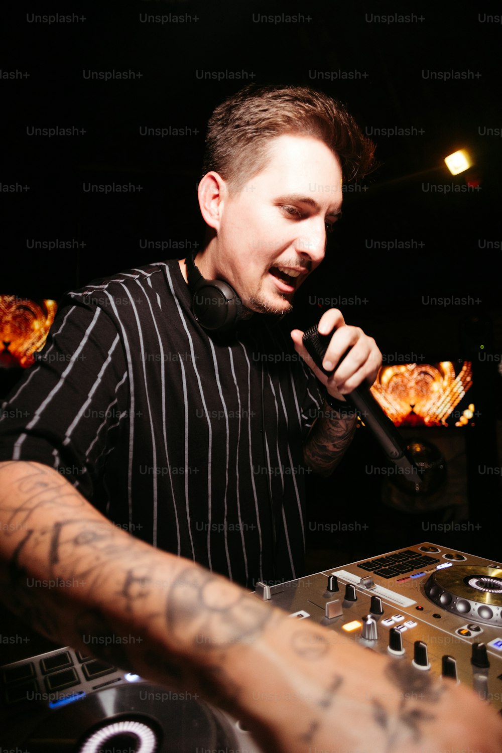 um homem em uma camisa listrada preta e branca segurando um microfone