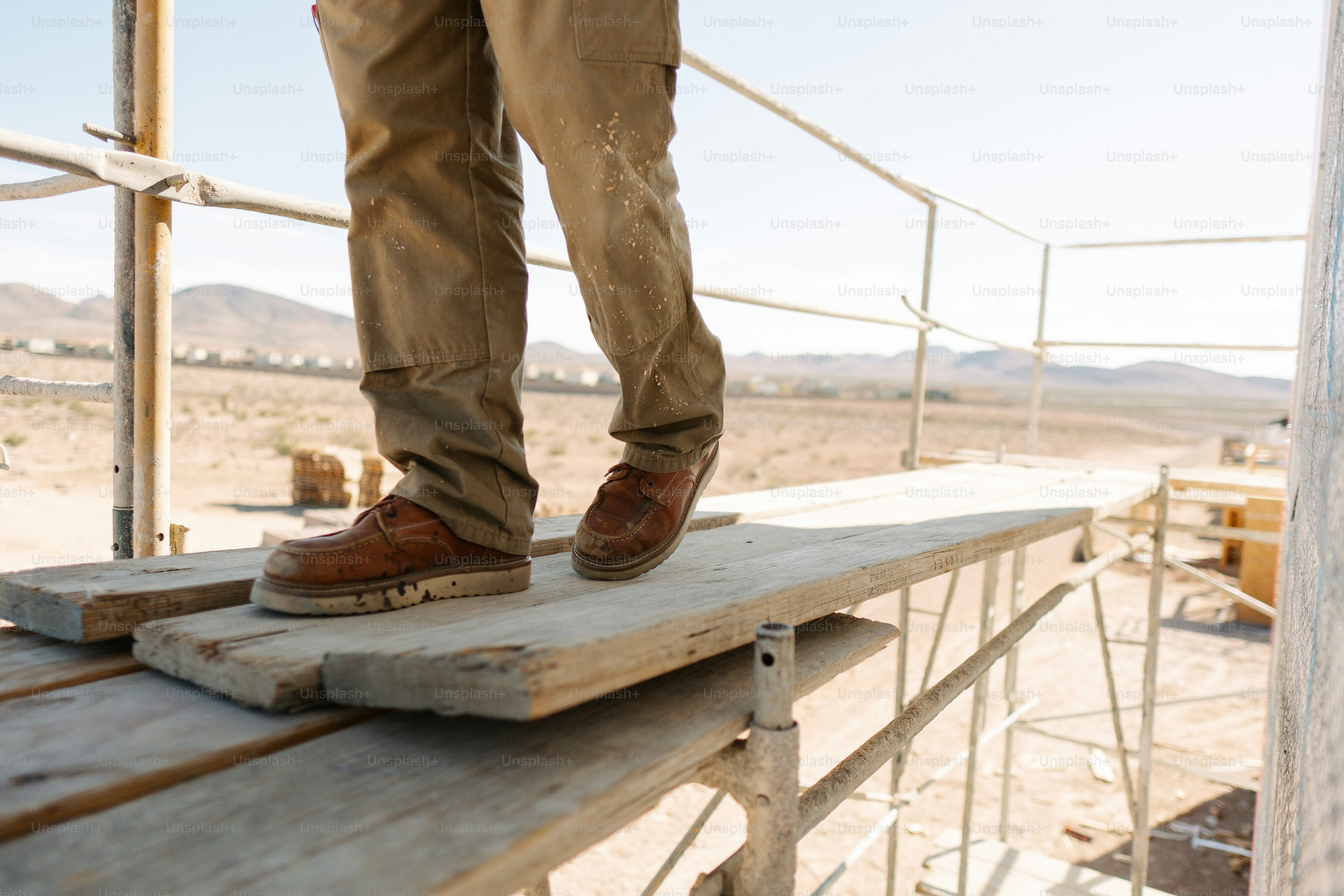 A person standing on top of a wooden platform photo – Construction ...