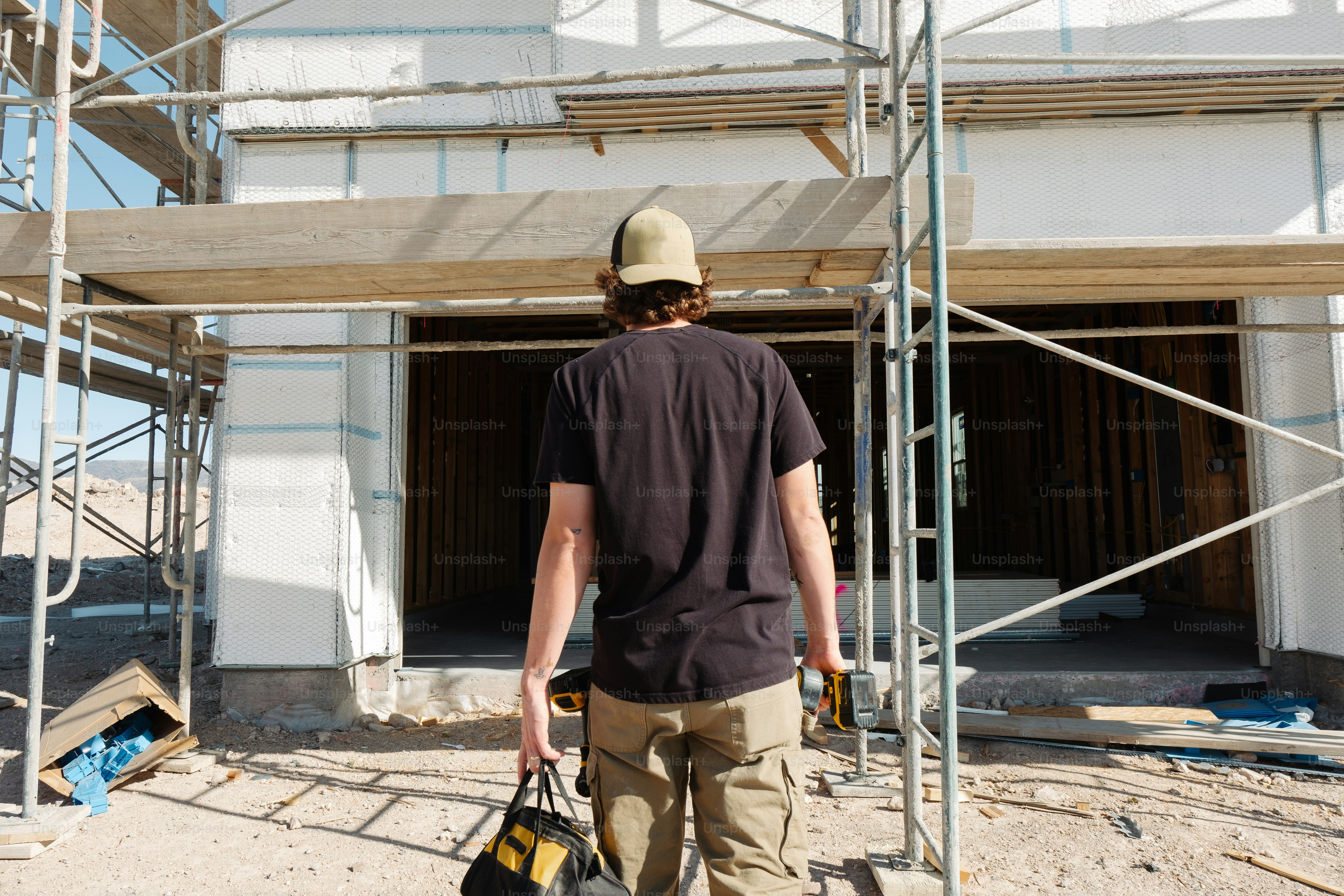 a construction worker carrying a bag of construction materials