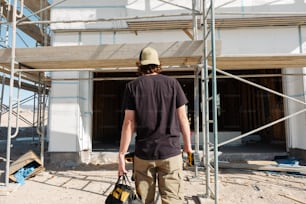 a construction worker carrying a bag of construction materials