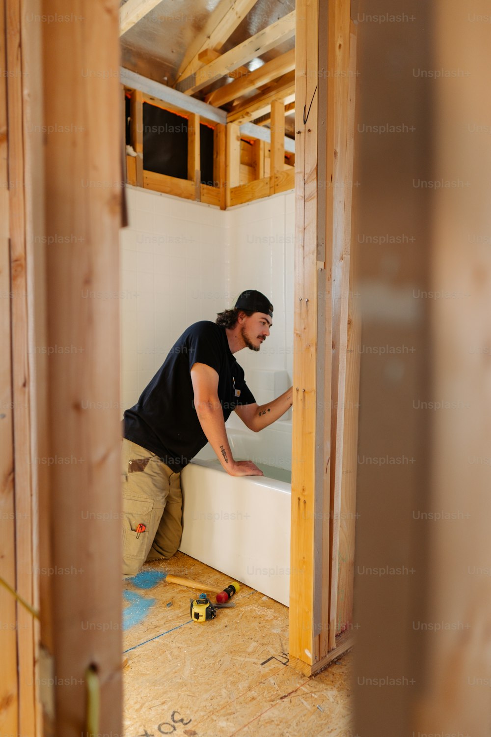 a man working on a wall in a room under construction
