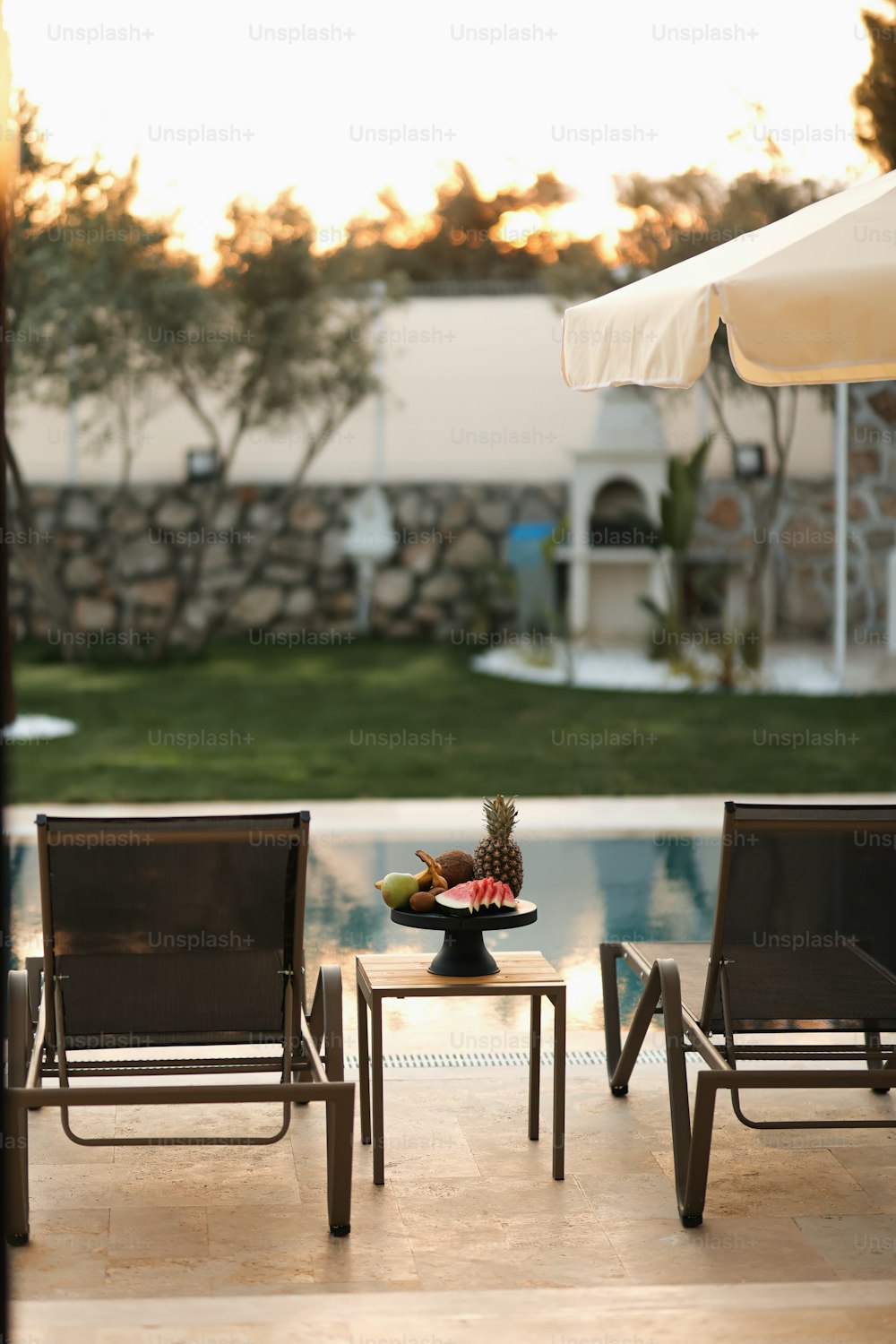 a couple of lawn chairs sitting next to a pool