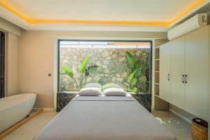 un dormitorio con una pared de piedra y una gran ventana