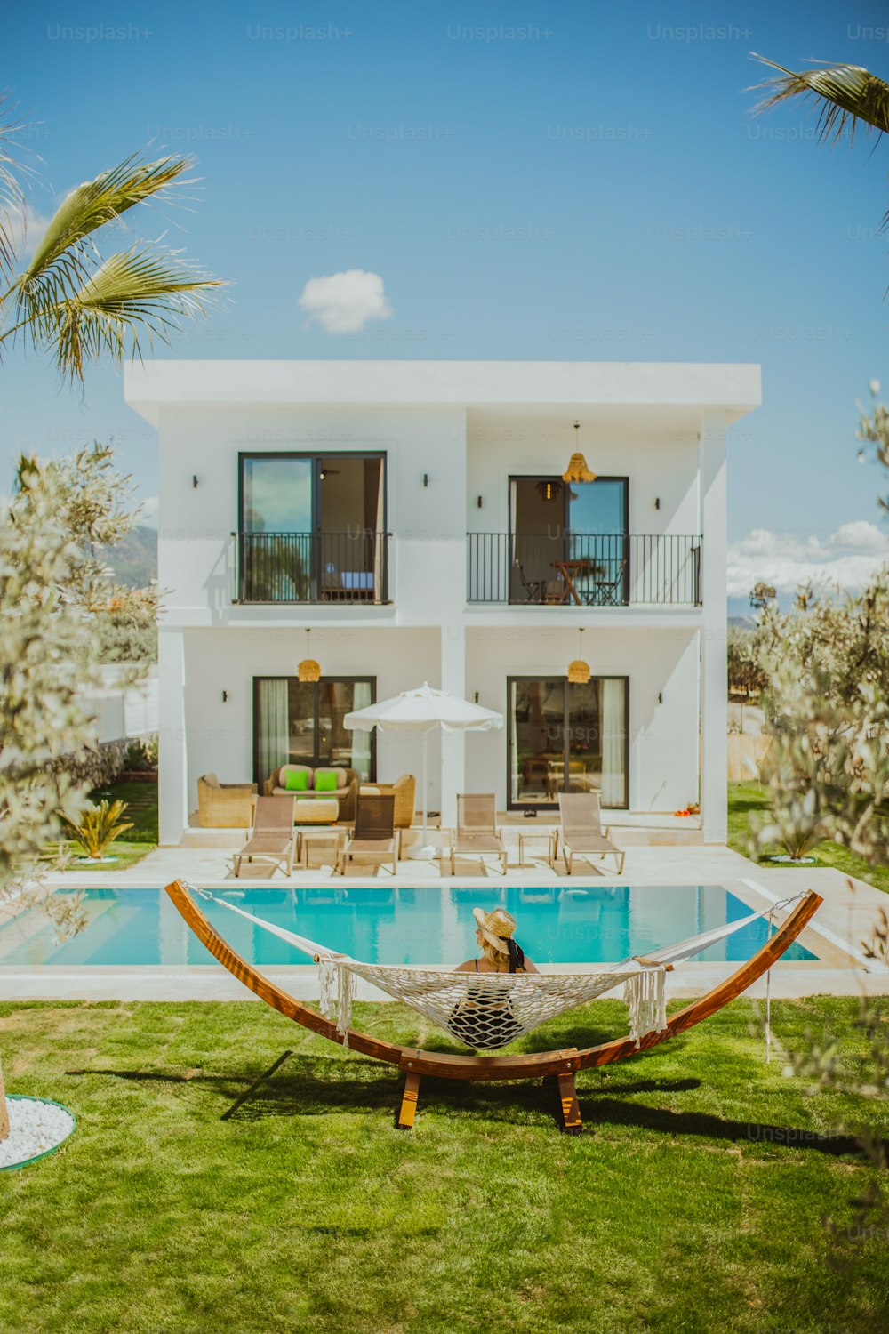 a person sitting in a hammock in front of a house