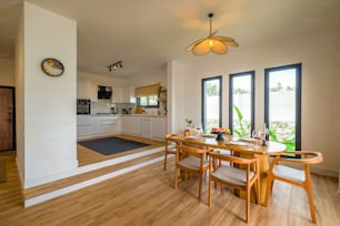 a dining room table with chairs and a clock on the wall