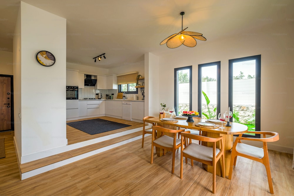 a dining room table with chairs and a clock on the wall