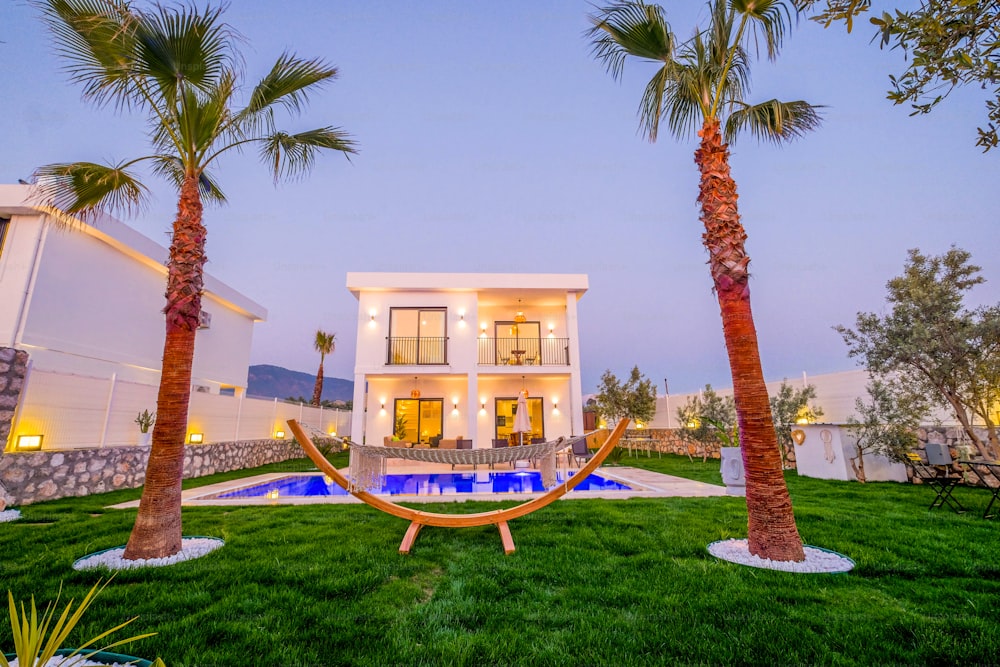 a house with a hammock between two palm trees