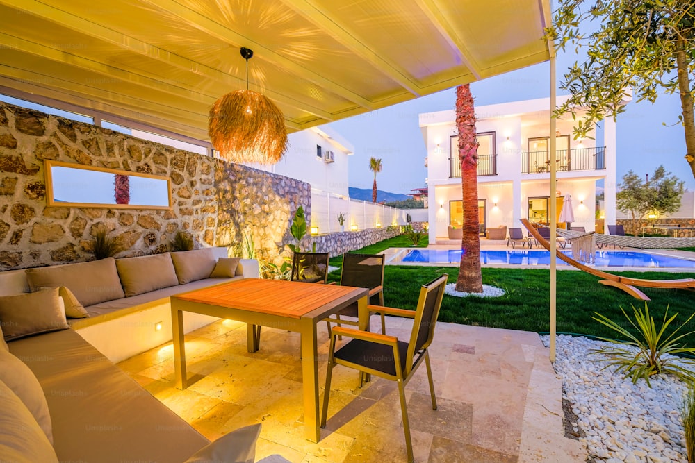 a patio with a table and chairs next to a swimming pool