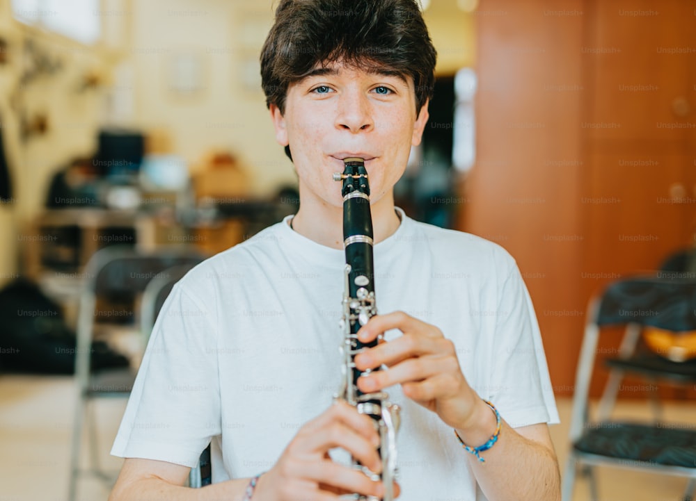 um jovem tocando flauta em uma sala